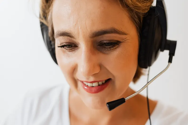 Atendente sorrindo com headset durante uma ligação